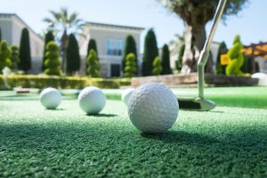 Instalación de Césped Artificial artificial grass hotel Mini golf scene with ball and club